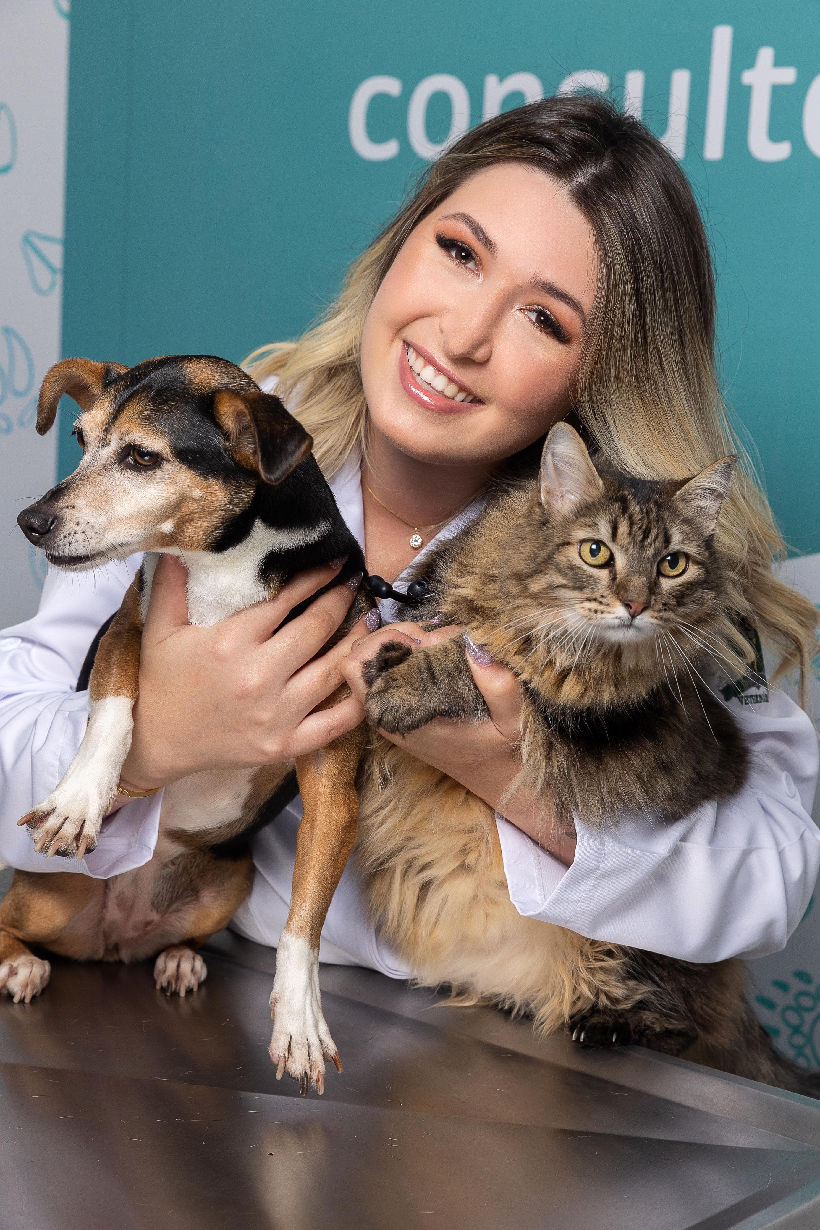 Dra. Luiza Scholz segurando um cachorro e um gato ao mesmo tempo