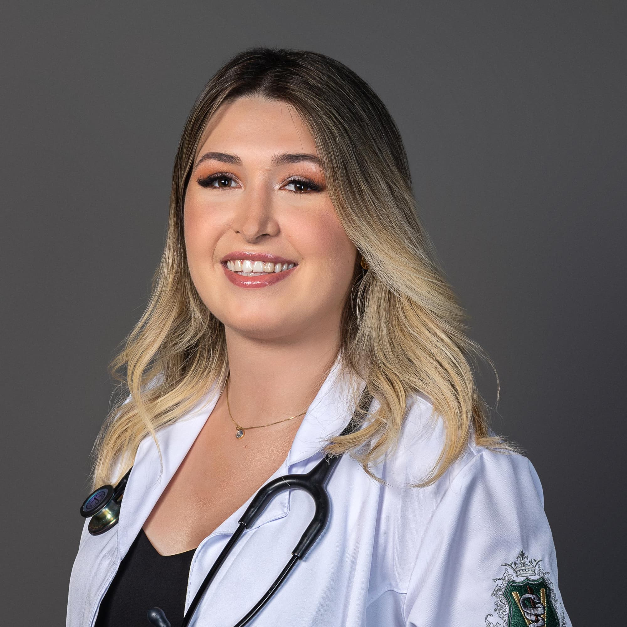 Dra. Luiza Scholz, médica veterinária e pet sitter em Joinville, de jaleco e estetoscópio